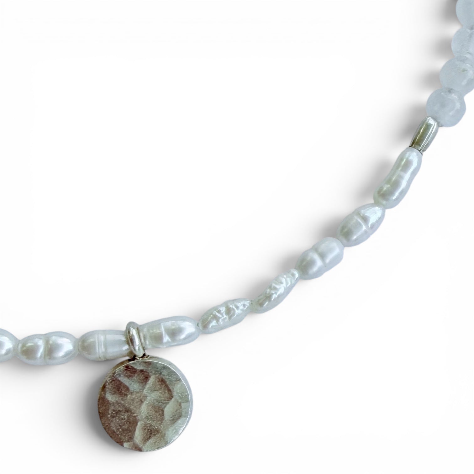 Close-up of the Lunaria necklace featuring freshwater rice pearls and a hammered sterling silver coin pendant
