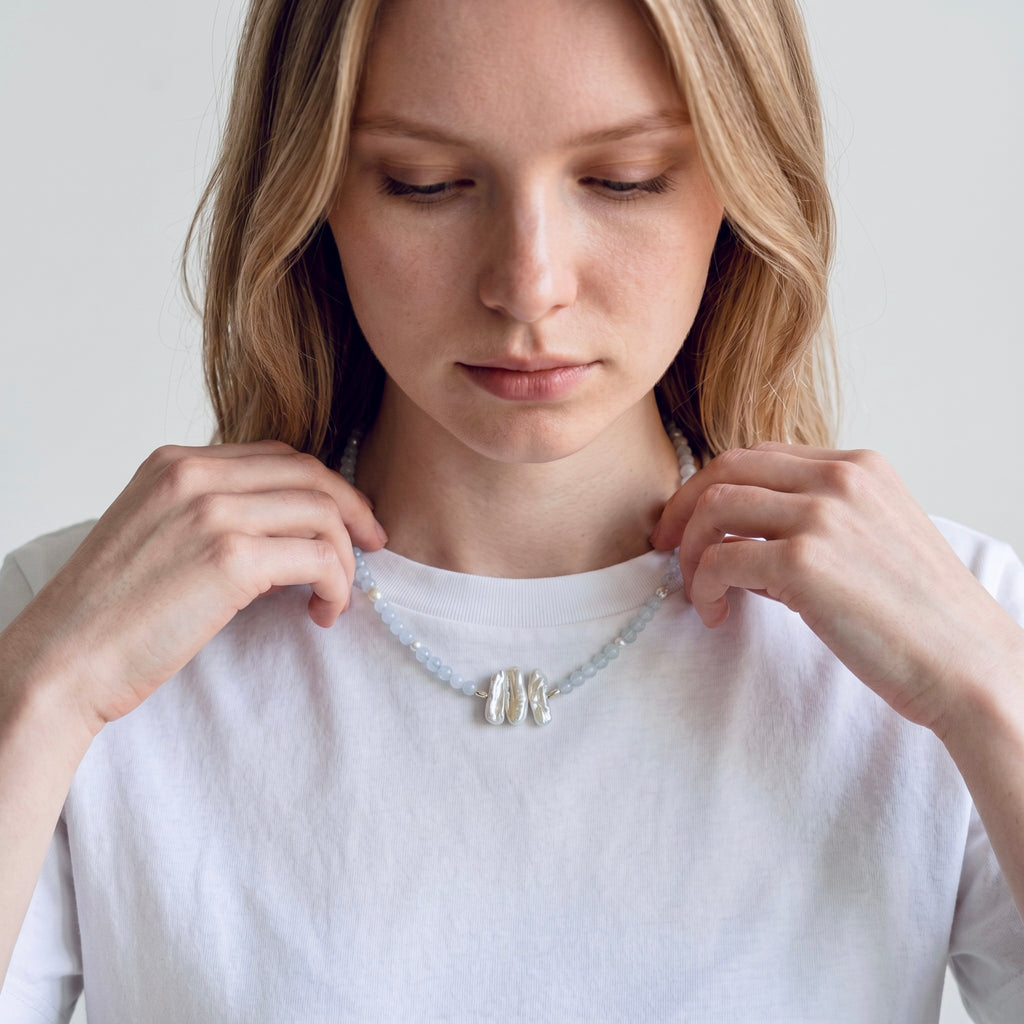 Close-up of model wearing the Nerida white chalcedony and baroque freshwater pearl sterling silver necklace